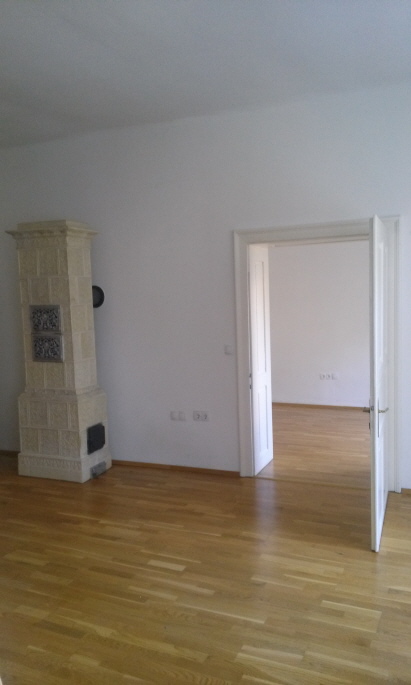 Wohnzimmer Blick auf Kachelofen und ins Schlafzimmer