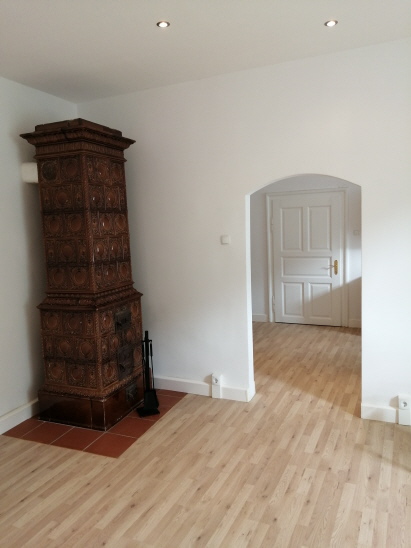 Blick vom Wohnzimmer in die Küche auf Eingangstüre, Küchenblock und Sitzecke